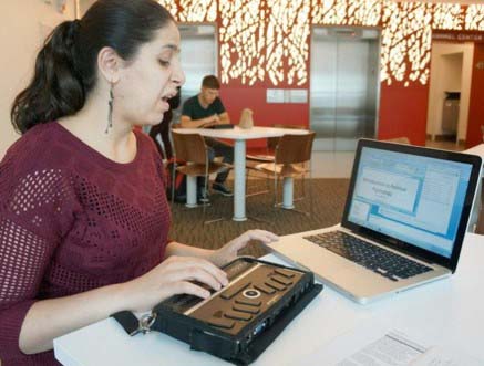 Student with braille note-taker and open laptop